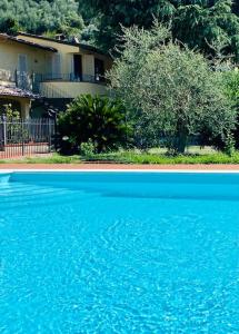 a large pool of blue water in front of a house at Casa BelMoro con piscina in Pescia