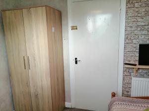 a room with a white door and a wooden cabinet at Park House in Leicester