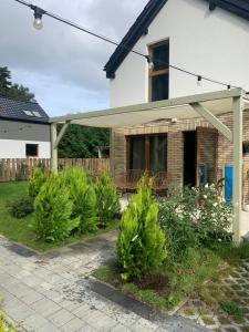 a house with a porch and some bushes at Pieprz i WANILIA Kopalino domek z widokiem na las 3 pokoje parking taras WiFi - Wanilia in Kopalino