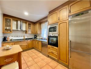 a kitchen with wooden cabinets and stainless steel appliances at Casa Outeiro in Betanzos