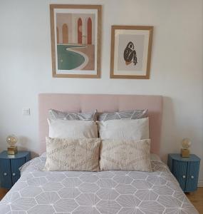 um quarto com uma cama com duas fotografias na parede em Jolie Dépendance em Le Brucat