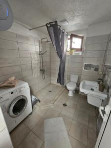 a bathroom with a washing machine and a sink at Апартамент за гости Криси гр. Девин in Devin +8 photos