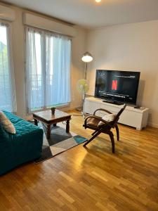 a living room with a couch and a tv at appartement Disneyland paris val d Europe la vallée village parking 600m gare RER in Montévrain