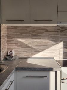 een keuken met witte kasten en een aanrechtblad bij Stan na dan Nova Varoš in Banja Luka