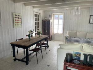a living room with a table and a couch at Les Olivettes in La Couarde-sur-Mer