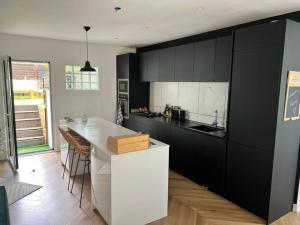 a kitchen with black cabinets and a white counter top at Appartement lumineux 6/pers in Lanester