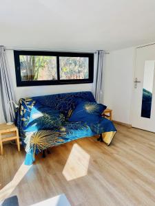 a bedroom with a blue bed and a window at Le cabanon de Manon - Marseille in Marseille