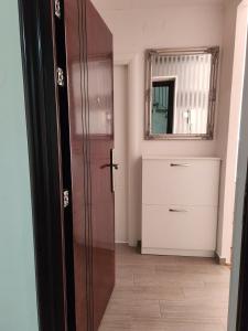 een badkamer met een houten deur en een spiegel bij Stan na dan Nova Varoš in Banja Luka +7 foto's