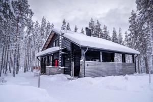 een blokhut in de sneeuw in een bos bij Charming log house - Lumous B - Pyhätunturi - Finland in Pyhätunturi