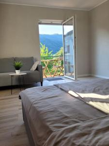 a bedroom with a bed and a couch and a window at Willi's Moselschlösschen in Neumagen-Dhron