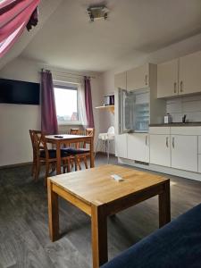 a living room with a table and a kitchen at Ferienwohnung Mond&Wasser 2 in Norden