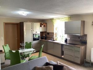a kitchen with a couch and a table with green chairs at Ferienhaus Wernesgrün in Wernesgrün