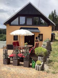 een huis met een tafel en stoelen en een paraplu bij Ferienhaus Wernesgrün in Wernesgrün