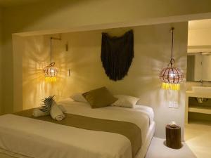 um quarto com uma cama com duas luzes em Isabella Boutique Hotel em Playa del Carmen
