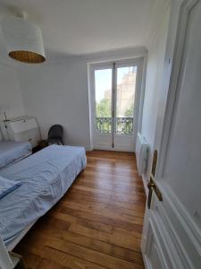 1 dormitorio con cama y ventana grande en Face château St Germain en Laye, appartement 4 à 6 personnes, 23 min de Paris Champs-Elysées, en Saint-Germain-en-Laye