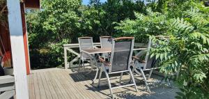 uma mesa e cadeiras sentadas num deque em Njut av solen, havet, stranden! em Sölvesborg