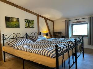a bedroom with a bed with a striped comforter at Neu renoviert: 11 Zimmer mit großer Wohnküche, mitten in der Natur in Neu Gaarz
