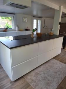 a kitchen with white cabinets and a black counter top at Chalet in Ursel in Aalter