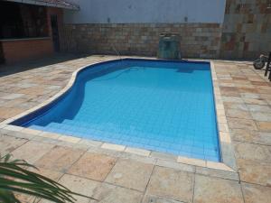 una piscina con azulejos azules en el suelo en Pousada das Acácias, en Carananduba