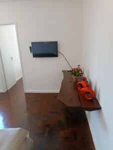 Habitación con mesa y TV en la pared. en Apartamento Completo, Diária ou Temporada, en Salvador