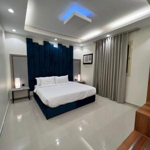 a bedroom with a large bed with a blue headboard at سيتي قولد للشقق الفندقيه in Taif