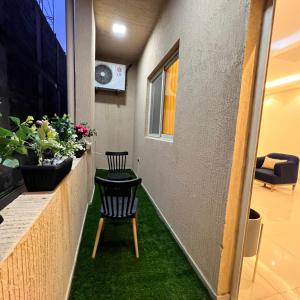 a hallway with a table and chairs and green grass at سيتي قولد للشقق الفندقيه in Taif