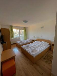 ein Hotelzimmer mit zwei Betten und einem Fernseher in der Unterkunft Pensiunea Sandra in Ocna Şugatag + 56 Fotos