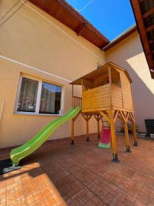 ein Spielplatz mit Rutsche und Spielhaus in der Unterkunft Pensiunea Sandra in Ocna Şugatag