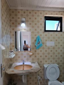 baño con lavabo y una persona que toma una foto en el espejo en Apartamento Completo, Diária ou Temporada, en Salvador
