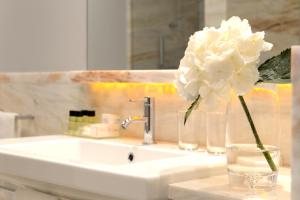 a white flower in a vase on a bathroom sink at Pestana Vintage Porto Hotel & World Heritage Site in Porto
