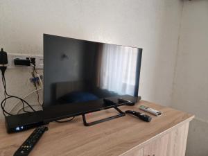 a television sitting on a table with two remote controls at Bem Downtown Apartment in Debrecen