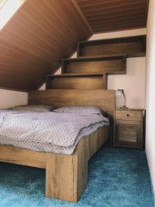 Posto letto in camera con soffitto in legno. di Podkrovní byt Bobrová 