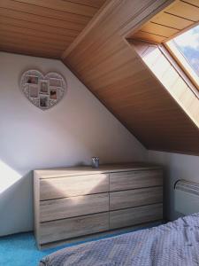 una camera da letto con cassettiera in legno in mansarda di Podkrovní byt Bobrová 