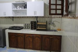 a kitchen with white cabinets and a sink and a stove at Yassers Residence in Er Rachidia
