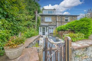 a stone house with a gate in front of it at Sunny Brae, Windermere Cottage in Windermere