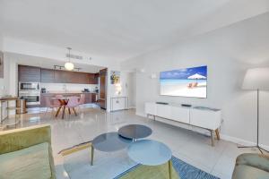 sala de estar con 2 mesas y cocina en Icon Luxury 34th Floor Amazing Oceanview, Brickell en Miami