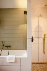 La salle de bains est pourvue d'une douche et d'une baignoire. dans l'établissement Boutiquehotel & Tiny houses PLEK17, à Milsbeek