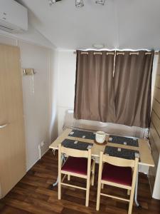 um pequeno quarto com uma mesa e duas cadeiras em Mobil-home grau du roi vagues Océanes em Le Grau-du-Roi
