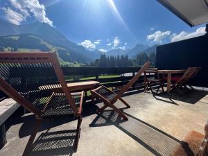 d'une table et de chaises sur un balcon avec vue sur les montagnes. dans l'établissement Schönes 2-Zimmer Studio mit grossem Balkon und Bergpanorama - 400m von Talstation Sillerenbahn, à Adelboden