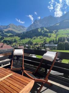 - deux chaises sur un balcon avec vue sur les montagnes dans l'établissement Schönes 2-Zimmer Studio mit grossem Balkon und Bergpanorama - 400m von Talstation Sillerenbahn, à Adelboden