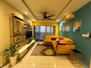 ein Wohnzimmer mit einem Sofa und einem TV in der Unterkunft Aqilla Homestay in Kuala Selangor