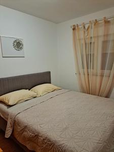 a bedroom with a bed and a curtain at Vikendica Vlahić, Goranci in Mostar