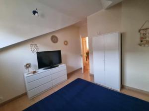 a living room with a television and a white cabinet at Apartament Mewa Gdańsk in Gdańsk