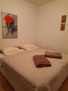 a bedroom with a bed with a red flower on it at Vikendica Vlahić, Goranci in Mostar
