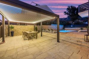 a patio with a table and chairs and a pool at Vila Kety in Baška