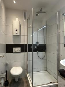 een badkamer met een douche, een toilet en een wastafel bij Apartment Düsseldorf-Lohausen in Düsseldorf