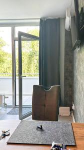 een woonkamer met een leren stoel en een tapijt bij Apartment Düsseldorf-Lohausen in Düsseldorf
