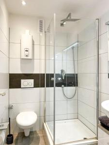 een badkamer met een douche, een toilet en een wastafel bij Apartment Düsseldorf-Lohausen in Düsseldorf