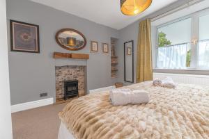 a bedroom with a large bed and a fireplace at Sunny Brae, Windermere Cottage in Windermere