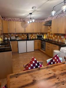 a large kitchen with a wooden table in it at Cosy Herne Bay Seaside Cottage in Kent